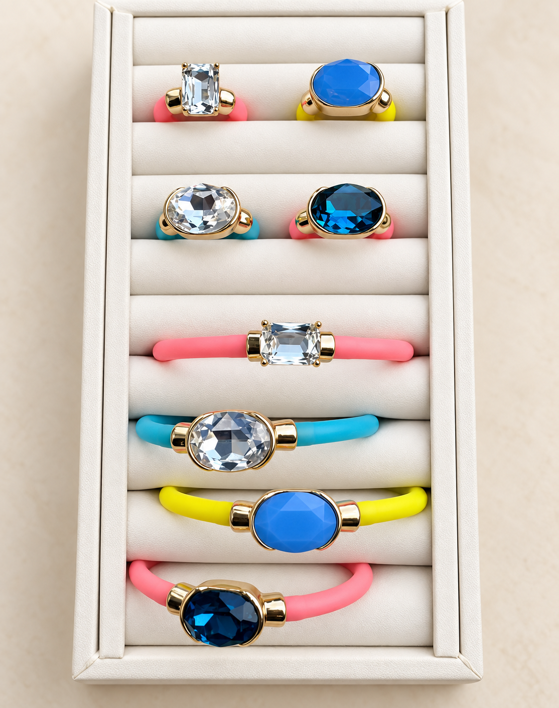 Bright gemstone bracelets and rings in pink, turquoise, yellow, crystal, and blue